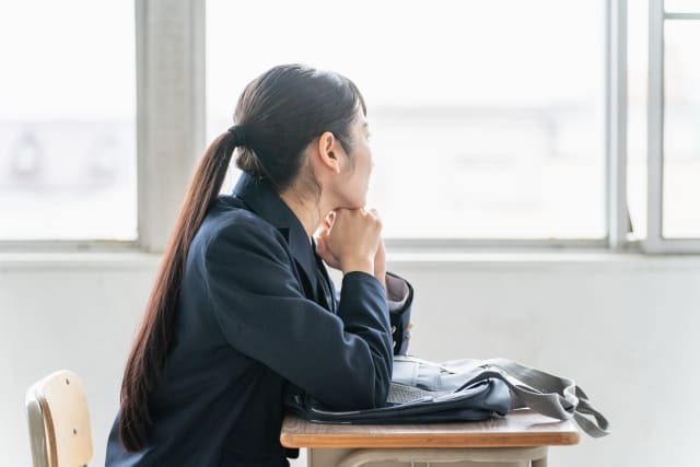 窓を見る中学生